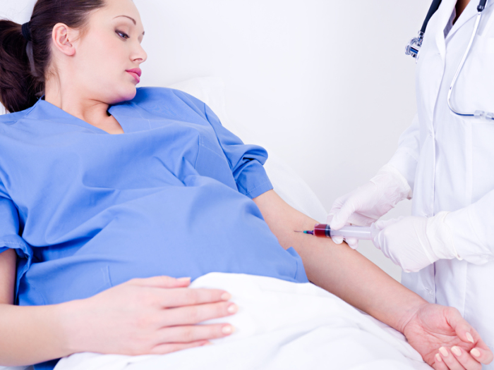 Doctor takes blood at the pregnant woman