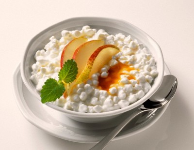 Granular fresh cheese with pear wedges in a bowl